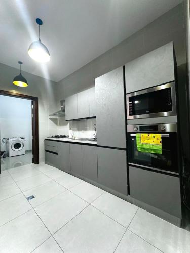 a kitchen with a stove and a microwave at Luxury House in Brazzaville
