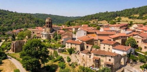 a village on a hill with houses and a tower at Chalet 3 étoiles - Piscine - eeiigg in Brioude
