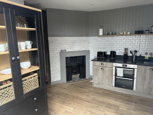 a kitchen with a stove and a fireplace at Woodstock Nest in Woodstock