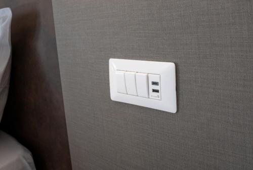 a white electrical outlet on the side of a wall at Tiber Suite in Rome