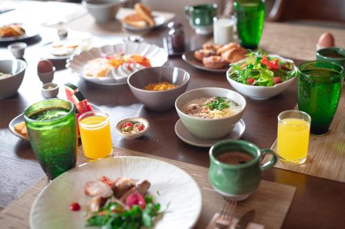 een tafel met borden en kopjes sinaasappelsap bij Pakasai Resort in Ao Nang Beach