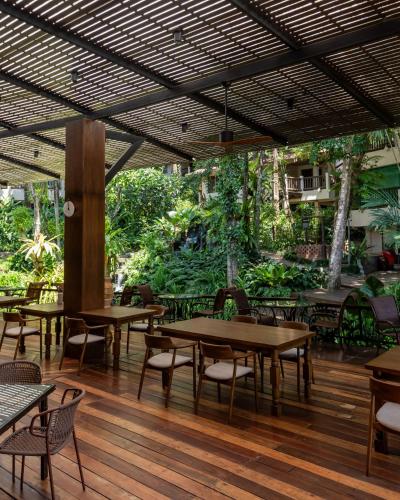 een restaurant met tafels en stoelen op een houten vloer bij Pakasai Resort in Ao Nang Beach