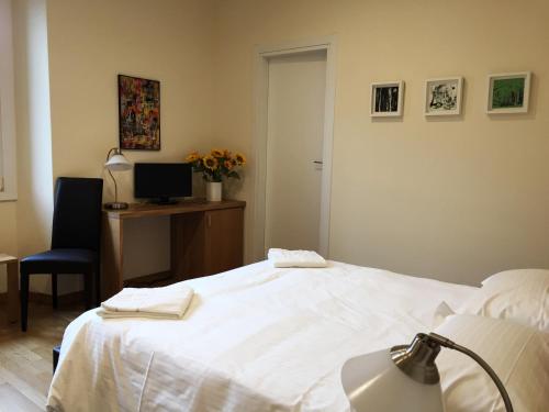 a bedroom with a bed and a desk with a computer at Hotel Trieste in Morbegno