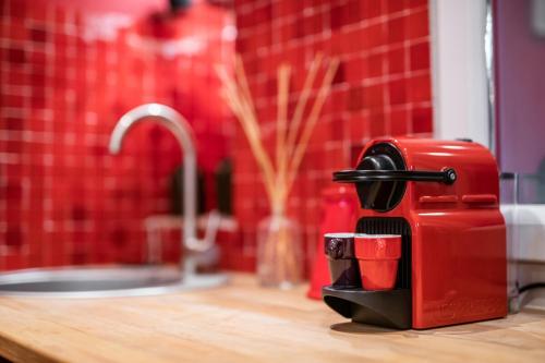 un grille-pain rouge assis sur un comptoir à côté d'un évier dans l'établissement 