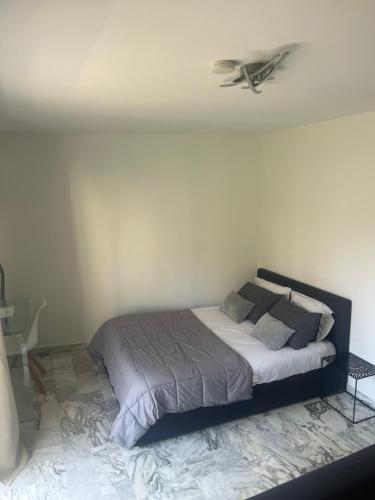 une chambre avec un lit avec un ventilateur de plafond dans l'établissement Studio meublé, les tambourins, à Cannes