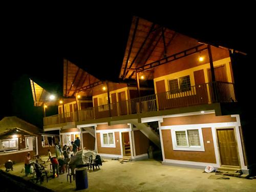 a group of people standing outside of a building at night at Aindra Coorg By Dazzle Destinations - Water Activities and Private Rooms in Subrahmanya