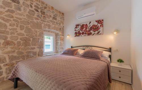 Un dormitorio con una cama y una pared de piedra. en Villa Veronika - Makarska by Villas Guide, en Skako