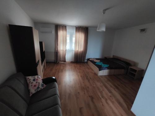 a living room with a couch and wooden floors at Varipatti House in Slatina