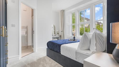a bedroom with a king sized bed and a window at Luxury 3-Bed Cirencester Apartment with garden, parking and EV charger in Cirencester