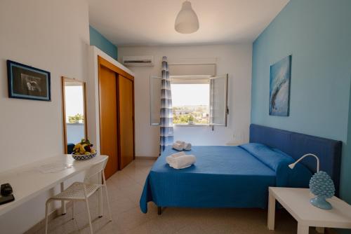 a blue bedroom with a blue bed and a desk at Residence Le 4 Stagioni in Menfi