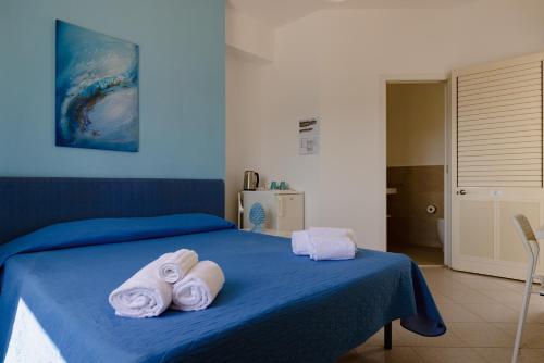 a blue bed with towels on top of it at Residence Le 4 Stagioni in Menfi