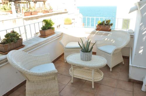 a balcony with chairs and a table and the ocean at B&B Casa Dorsi in Polignano a Mare
