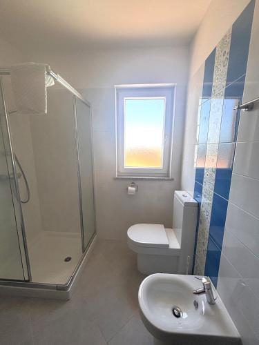 a bathroom with a toilet and a shower and a sink at Apartments Quarnero Rabac in Rabac