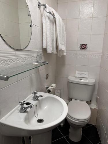 a bathroom with a toilet and a sink and a mirror at The Old Manor House Hotel in Keynsham