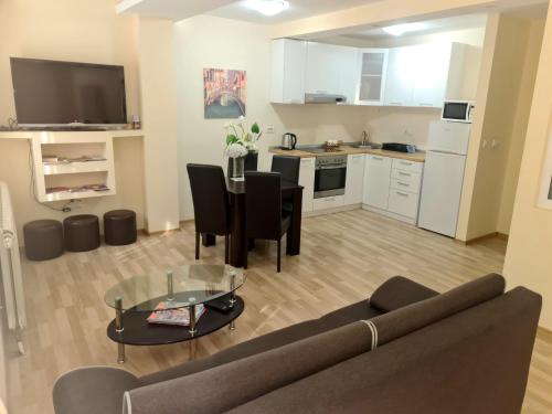 Una sala de estar con un sofá y una mesa y una cocina. en Fantastic Belgrade Nights, en Belgrado