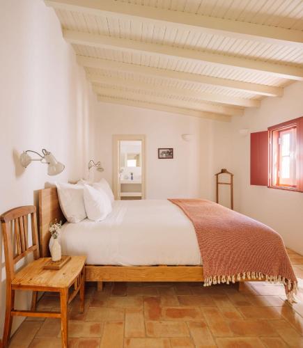 a bedroom with a large bed and a wooden table at Quinta do Pinheiro in Pinheiro