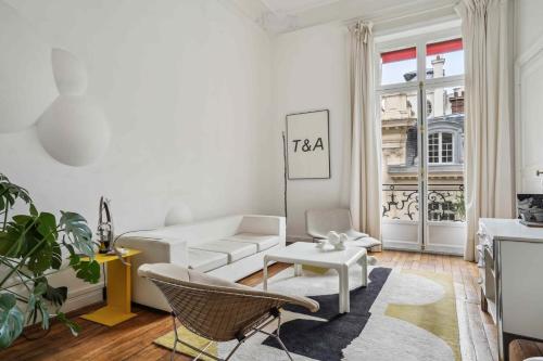 un salon avec un canapé blanc et une table dans l'établissement Le Fabuleux au coeur de Paris, à Paris