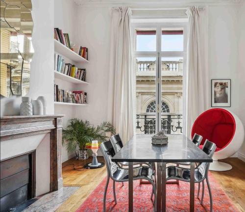 une salle à manger avec une table et des chaises et une cheminée dans l'établissement Le Fabuleux au coeur de Paris, à Paris