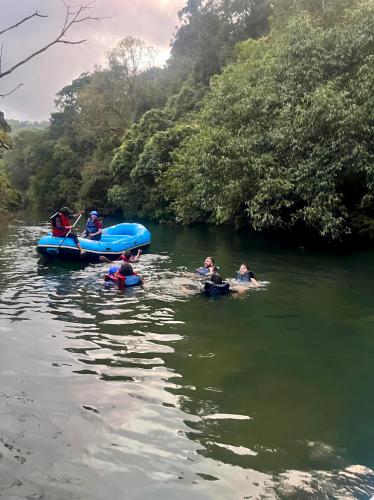 a group of people in a river on a raft at Aindra Coorg By Dazzle Destinations - Water Activities and Private Rooms in Subrahmanya