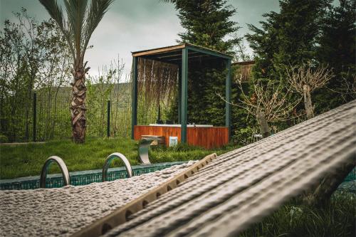 a hammock in a garden with a building in the background at Grand Paradise Resort Sapanca in Sapanca