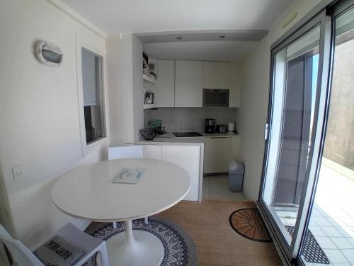 - une petite cuisine avec une table blanche dans une chambre dans l'établissement Le Crystal-studio terrasse pleine vue mer, à Dinard