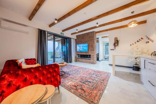a living room with a red couch and a fireplace at Grand Paradise Resort Sapanca in Sapanca