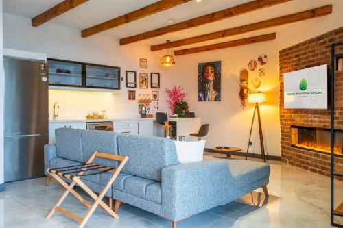 a living room with a blue couch and a fireplace at Grand Paradise Resort Sapanca in Sapanca