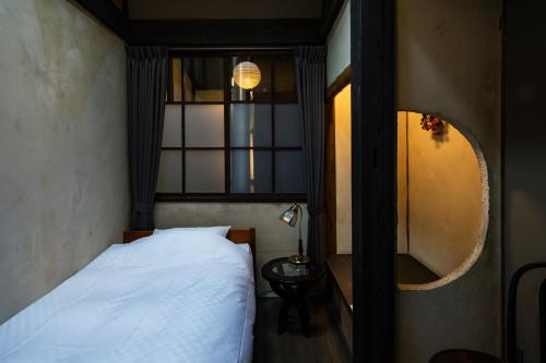a bedroom with a white bed and a mirror at UNKNOWN KYOTO in Kyoto