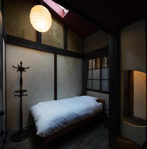 a bedroom with a bed with a cross on it at UNKNOWN KYOTO in Kyoto