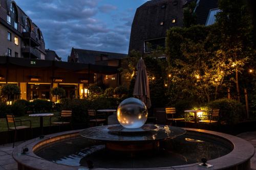 a large glass ball in a fountain with an umbrella at Le Louise Hotel Brussels - MGallery Collection in Brussels
