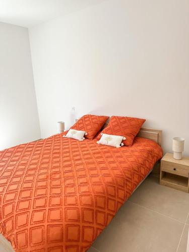 - une chambre avec un lit orange et 2 oreillers dans l'établissement Charmant T3 au coeur d'Ajaccio, à Ajaccio