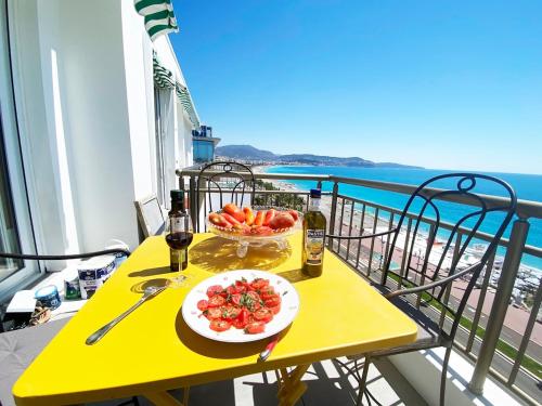 une table jaune avec une assiette de fruits sur un balcon dans l'établissement 