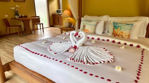 a bed with a swan decoration on it at Deva Beach Resort Samui in Choeng Mon Beach