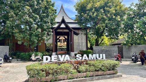 a sign in front of a house with a building at Deva Beach Resort Samui in Choeng Mon Beach