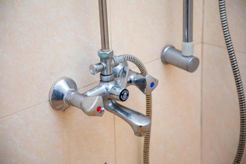 a metal shower faucet in a bathroom at Oasis Homestay in Arusha