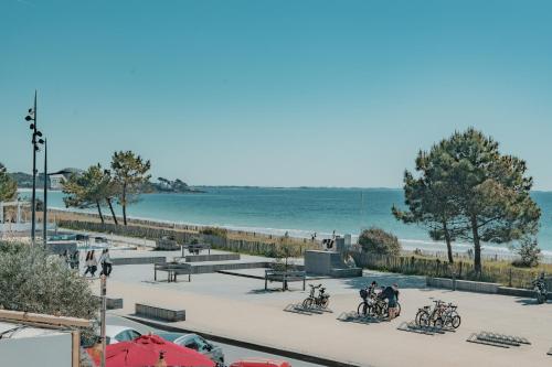a view of a beach with people and bikes at Hôtel Édenia - Spa Estime&Sens in Carnac