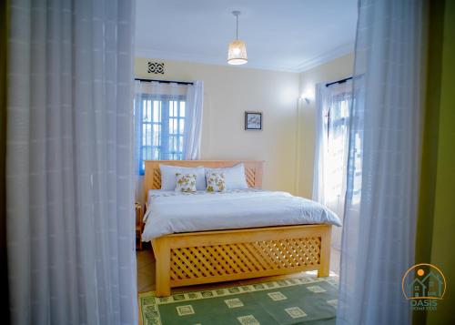 a bedroom with a bed in a room with windows at Oasis Homestay in Arusha
