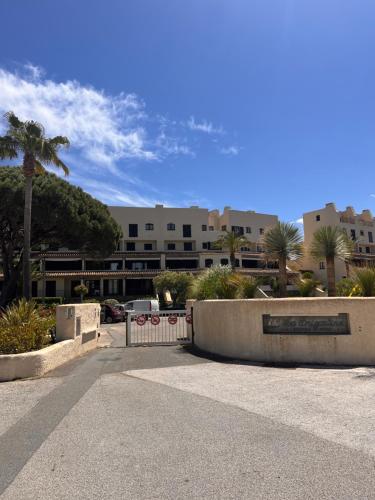 a parking lot in front of a building with palm trees at Coup de cœur BB in Cogolin
