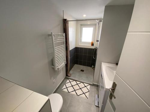 Elle comprend une petite salle de bains pourvue de toilettes et d'une fenêtre. dans l'établissement Maison avec piscine proche plages, à Anglet