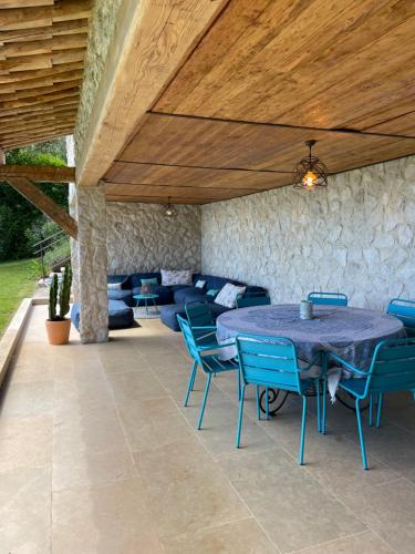 un patio avec une table, des chaises et un canapé dans l'établissement Luxueuse villa avec vue village et mer sur saint Paul de Vence, à Saint-Paul-de-Vence