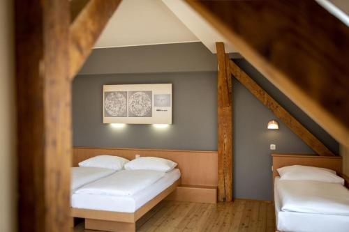a bedroom with two beds in a attic at JUFA Hotel Judenburg - Self Check-In in Judenburg