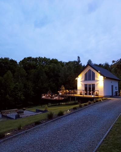 a house with lights on the side of a road at Domek Na Wądołach in Jedlicze