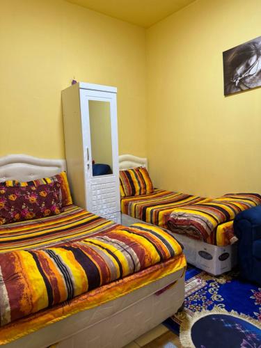 a bedroom with two beds and a mirror at MAMA DELiGHT HOME in Abu Dhabi