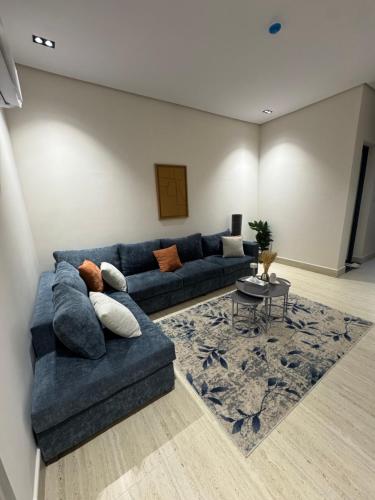 a living room with a blue couch and a table at The Rose Apartment الدمام in Al Fayşalīyah