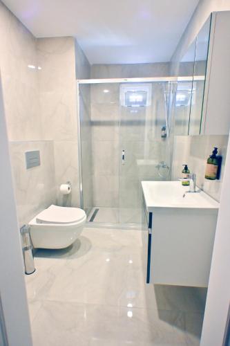 a bathroom with a shower and a toilet and a sink at The Han YK Hotel in Avcılar