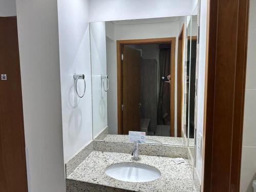 a bathroom with a sink and a mirror at Apartamentos Riviera Park in Caldas Novas