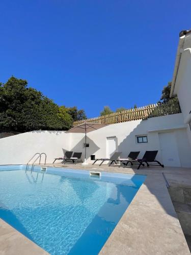 une piscine avec deux chaises à côté d'une maison dans l'établissement Casetta Amandina Pinarellu, à Pinarellu