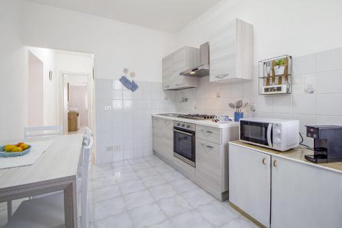 a kitchen with white appliances and a counter top at S'ammentu in Sassari