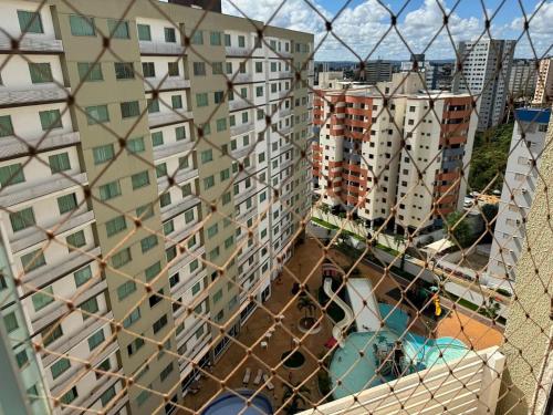 a view of buildings through a mesh fence at Apartamentos Riviera Park in Caldas Novas