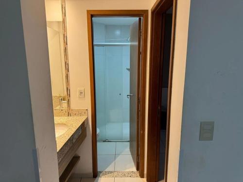 a bathroom with a glass shower and a sink at Apartamentos Riviera Park in Caldas Novas
